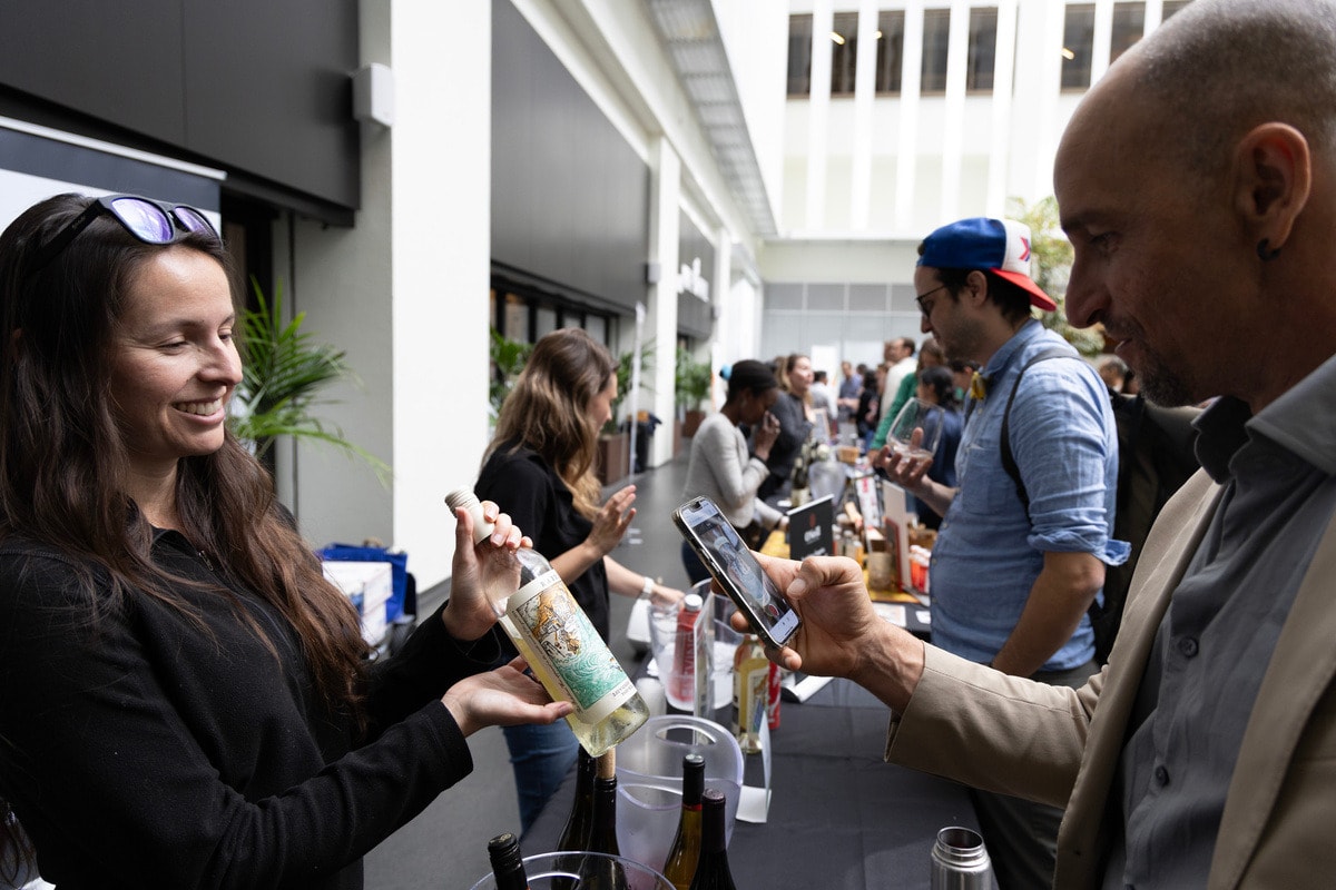 Guests tasting and photographing wines at the Sustainable Food and Wine Festival