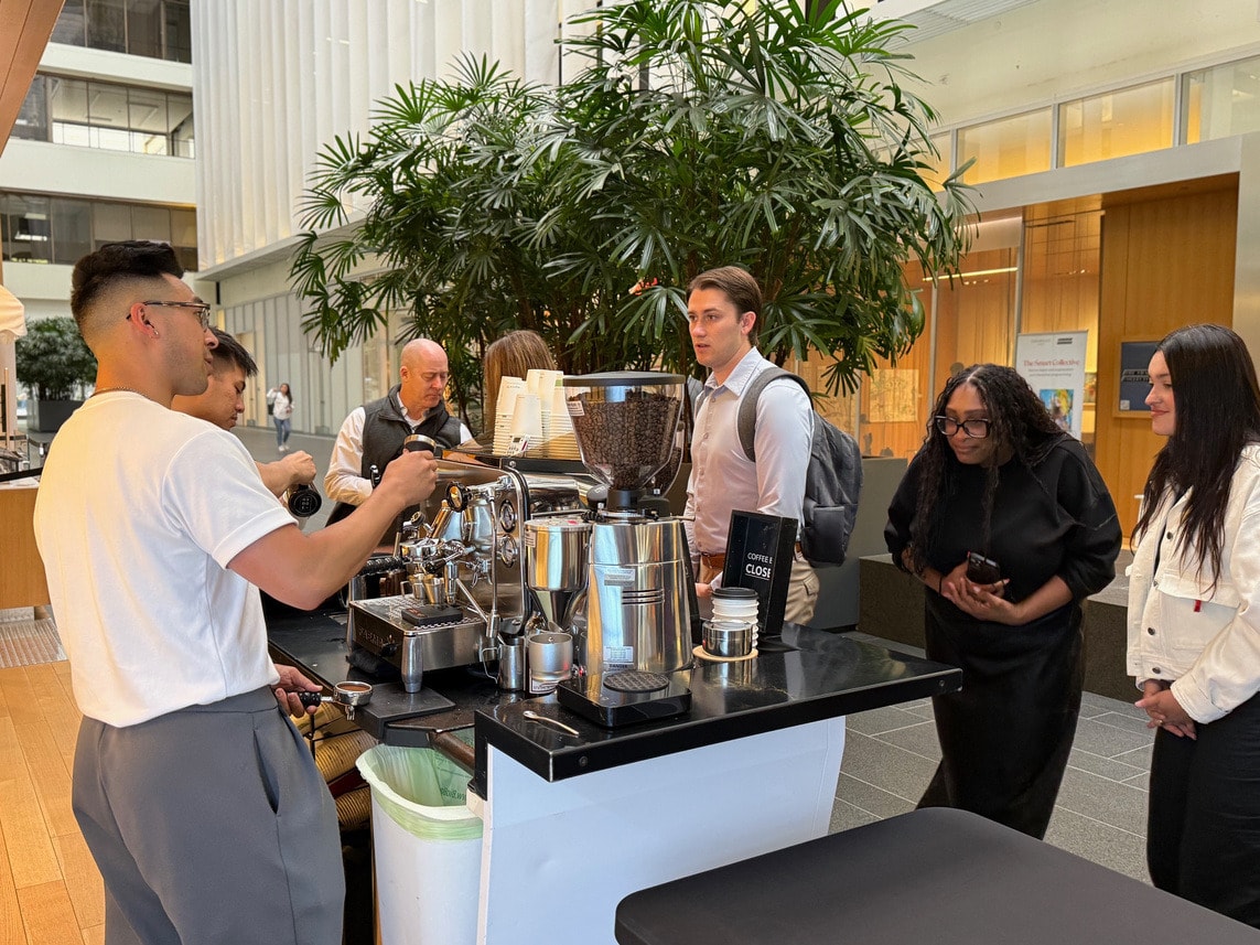 A barista serving coffee from a pop-up cart as tenants gather