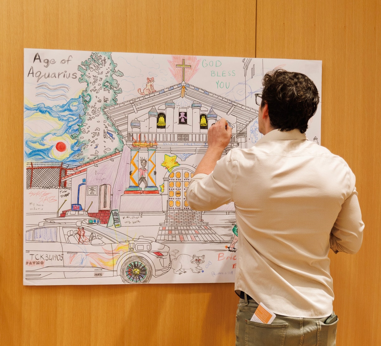 A participant painting a large illustration at an arts workshop